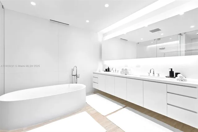 a bathroom with a bathtub a mirror a sink and vanity