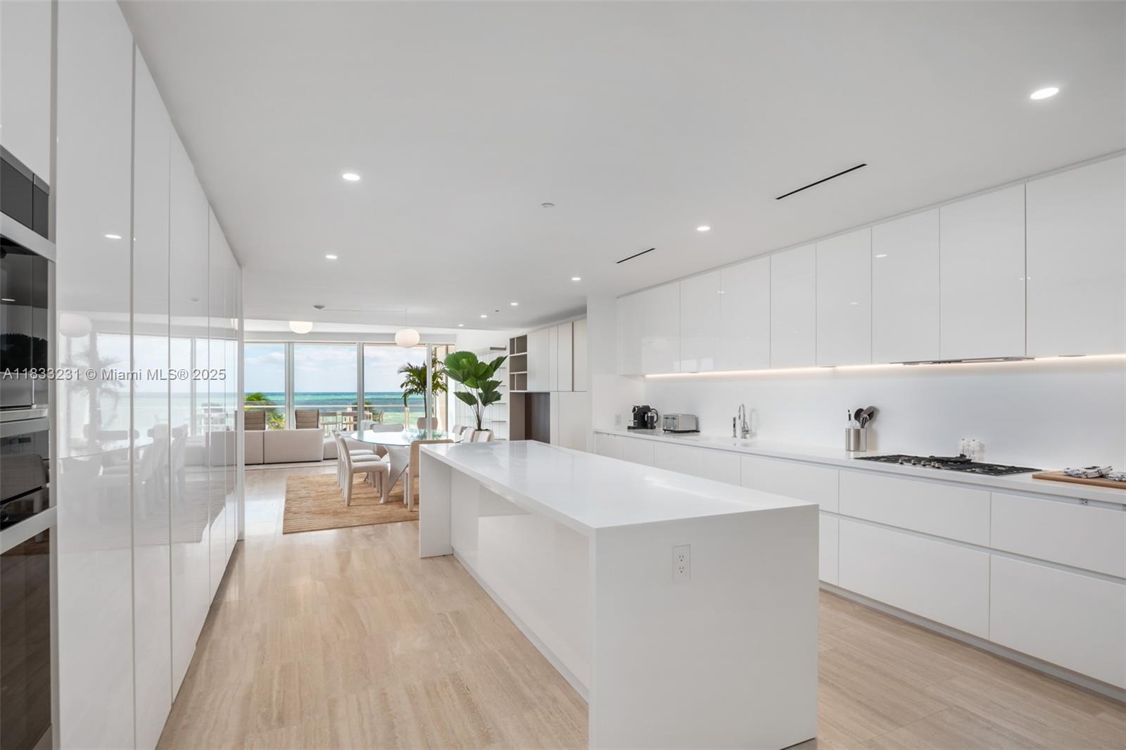 9001 Collins Avenue, Unit S305 Surfside, FL 33154 - Photo 14 of 23 a large white kitchen with a lot of counter space