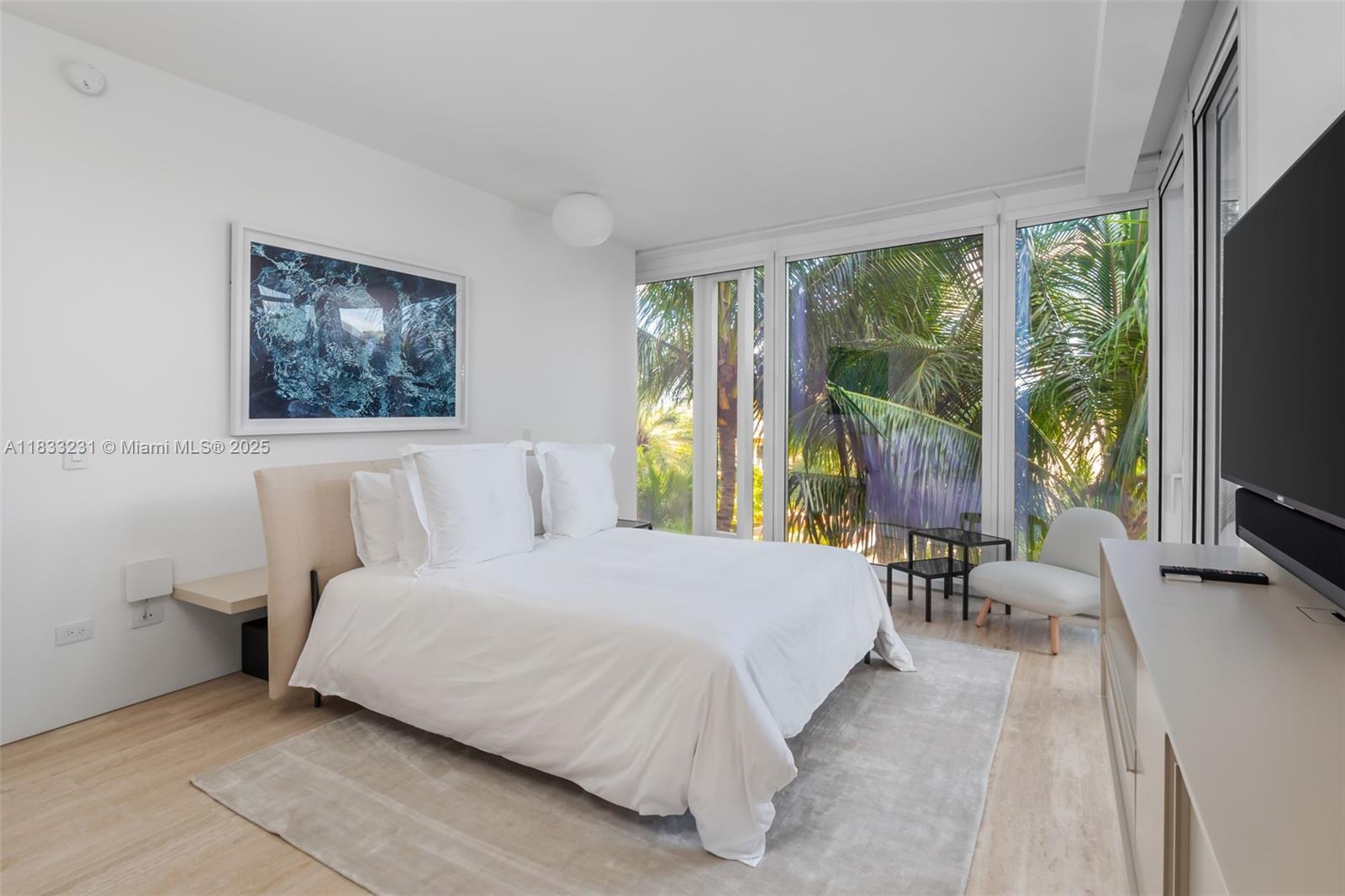 9001 Collins Avenue, Unit S305 Surfside, FL 33154 - Photo 17 of 23 a bedroom with a large bed couch and a large window