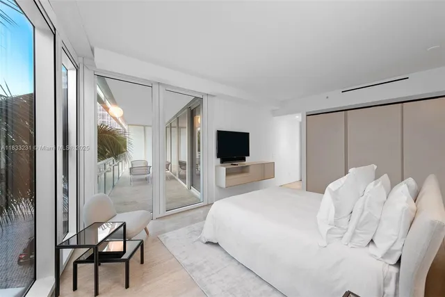 a bedroom with a bed and a flat screen tv