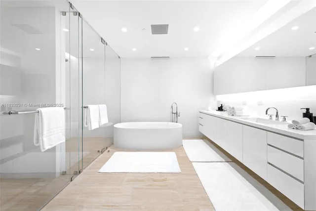 a bathroom with a tub a toilet and a double vanity