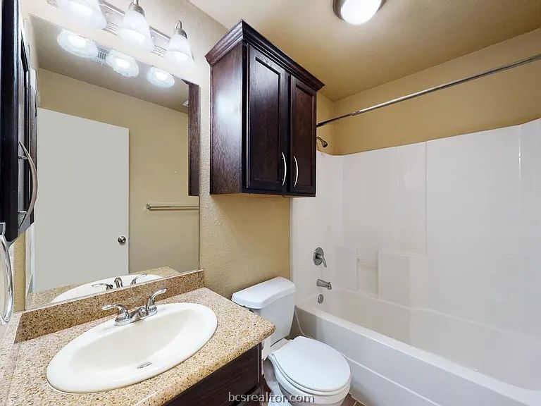 2024 Mountain Wind Loop Bryan, TX 77807 - Photo 11 of 14 a bathroom with a toilet sink and bathtub