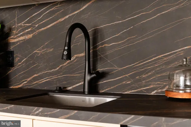 a kitchen with granite countertop a stove top oven a sink a dining table and chairs