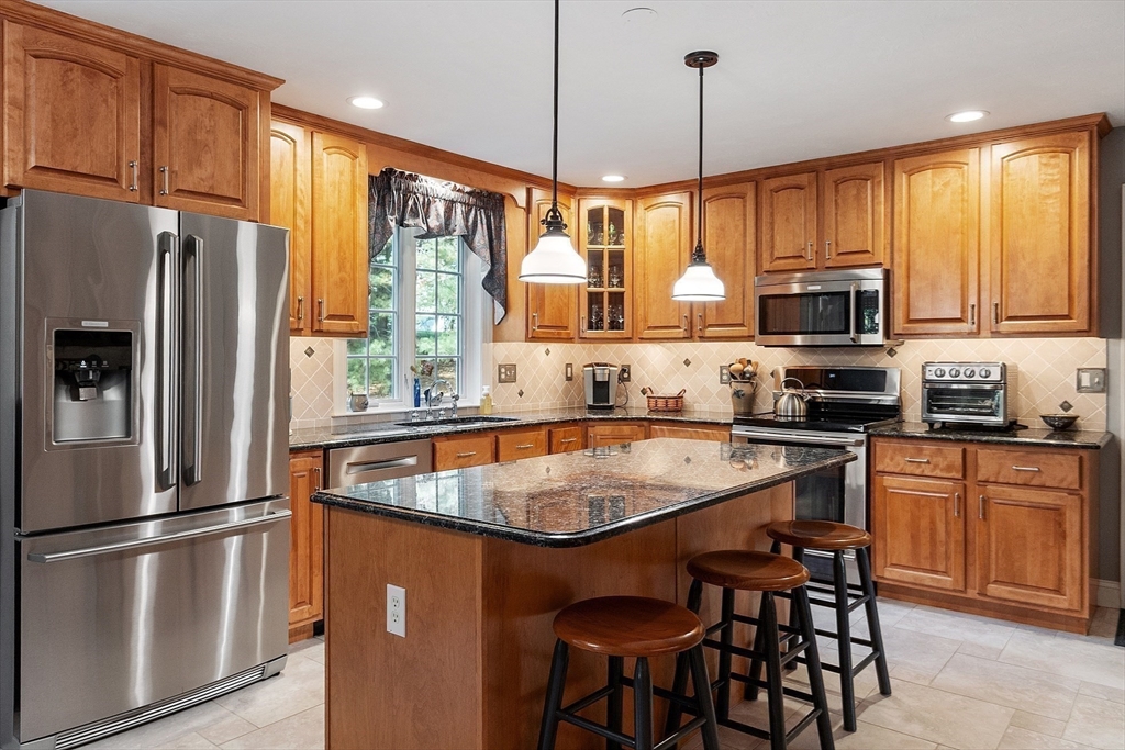2 Taymax Road Westminster, MA 01473 - Photo 5 of 41 a kitchen with stainless steel appliances granite countertop a refrigerator a stove a sink a dining table and chairs with wooden floor