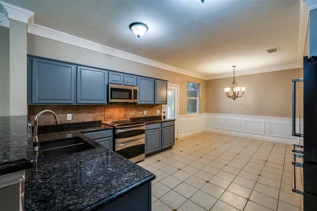 a kitchen with stainless steel appliances granite countertop a stove a sink and a microwave
