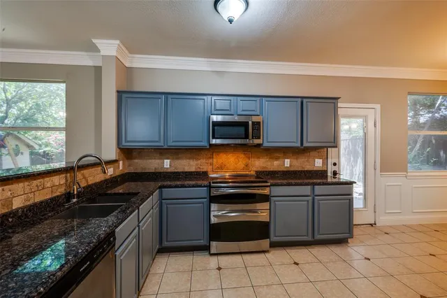 a kitchen with stainless steel appliances granite countertop a sink and stove top oven