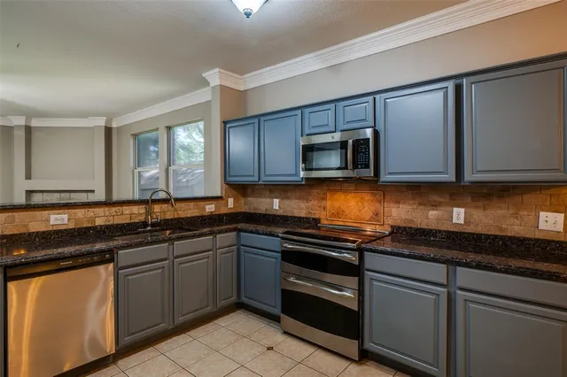a kitchen with stainless steel appliances granite countertop a sink stove and microwave