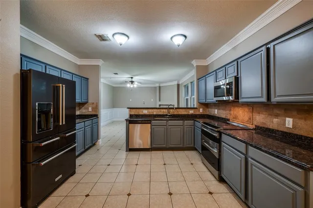 a kitchen with stainless steel appliances granite countertop a refrigerator and a stove top oven
