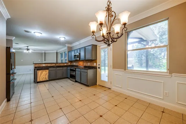 a kitchen with stainless steel appliances a counter top space cabinets and a chandelier