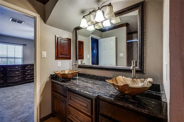 a bathroom with a granite countertop sink and a mirror