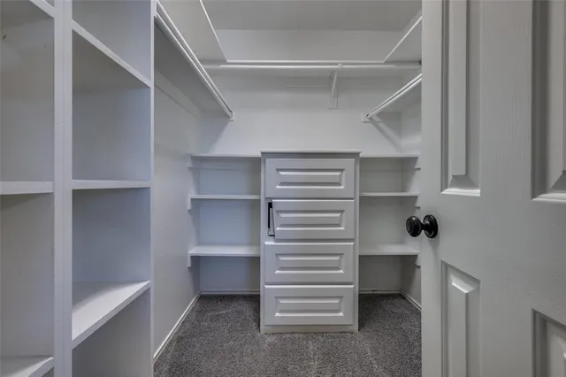 a view of walk in closet with empty racks