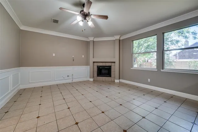 an empty room with windows and fireplace