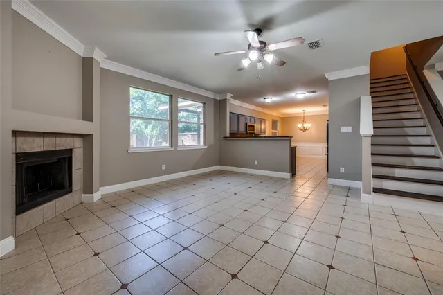 a view of an empty room with window and chandelier fan