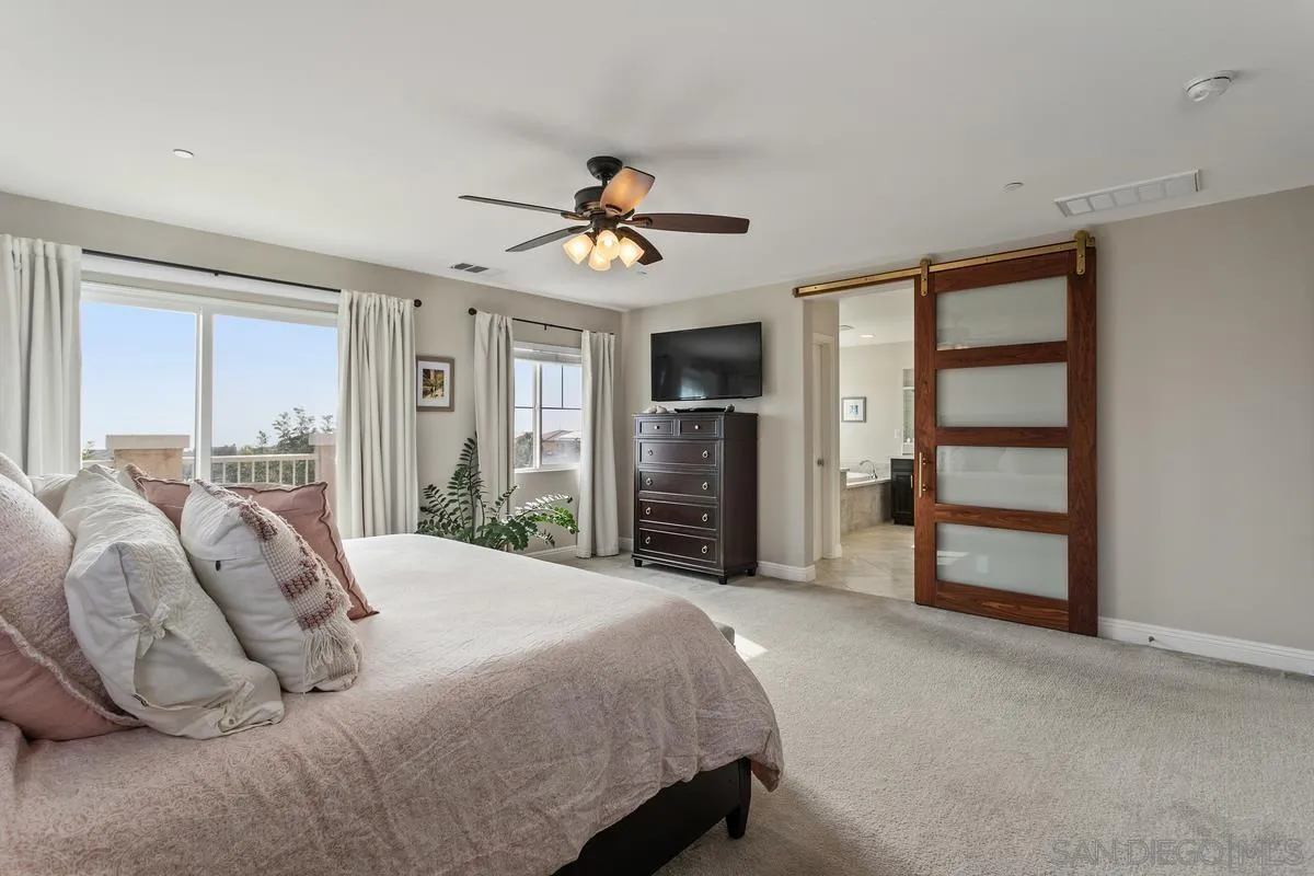 1014 Bellingham Drive Oceanside, CA 92057 - Photo 19 of 33 a spacious bedroom with a bed and a ceiling fan