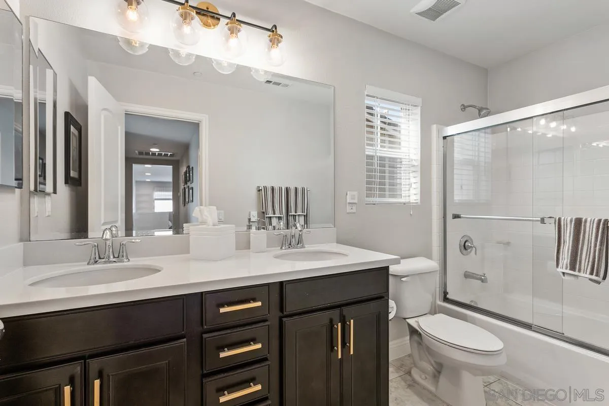 1014 Bellingham Drive Oceanside, CA 92057 - Photo 24 of 33 a bathroom with a sink a toilet a mirror and shower
