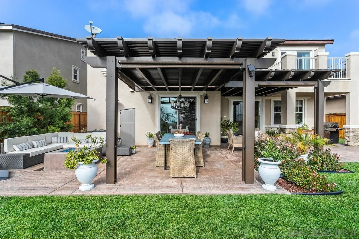 1014 Bellingham Drive Oceanside, CA 92057 - Photo 28 of 33 a view of a patio with table and chairs potted plants and large tree