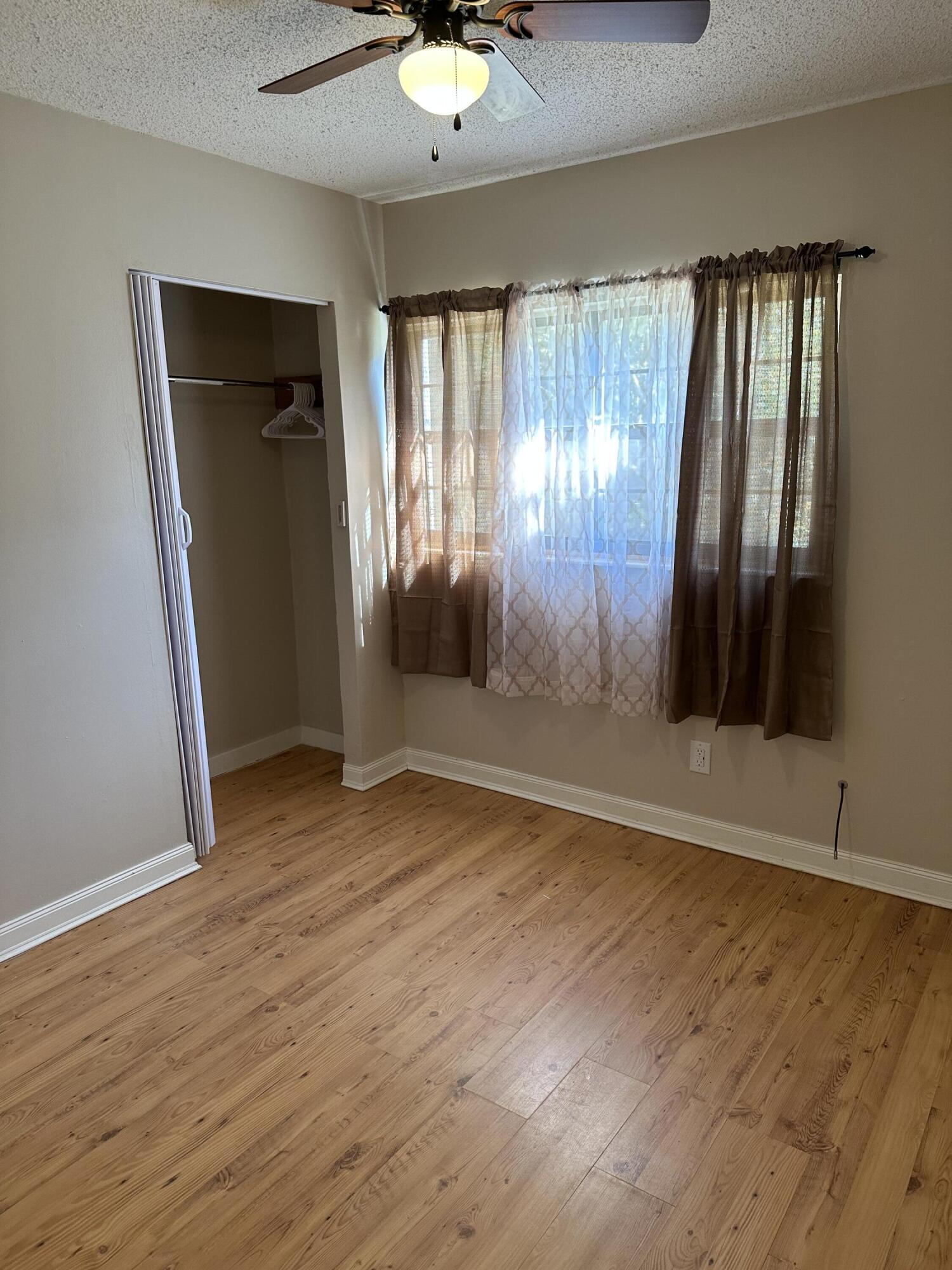 111 Sikes Drive Crestview, FL 32539 - Photo 12 of 20 an empty room with wooden floor and windows