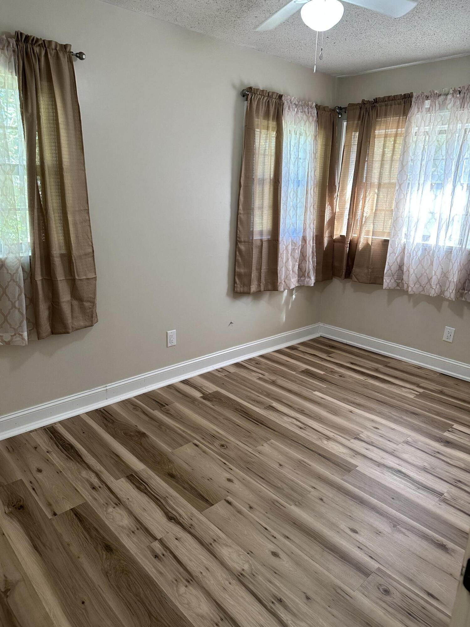 111 Sikes Drive Crestview, FL 32539 - Photo 15 of 20 a view of an empty room with wooden floor and a window