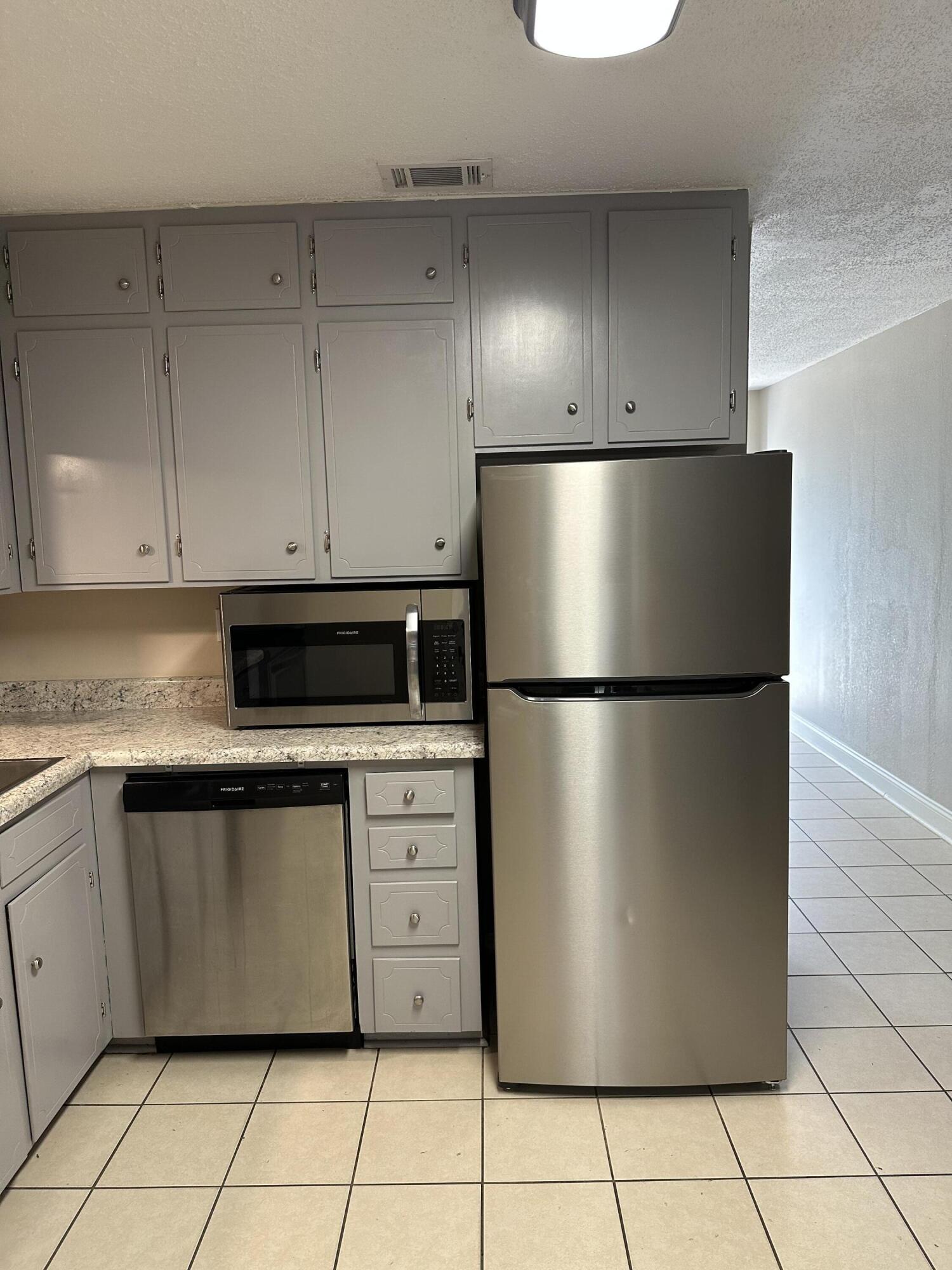 111 Sikes Drive Crestview, FL 32539 - Photo 4 of 20 a kitchen with granite countertop a refrigerator and white cabinets