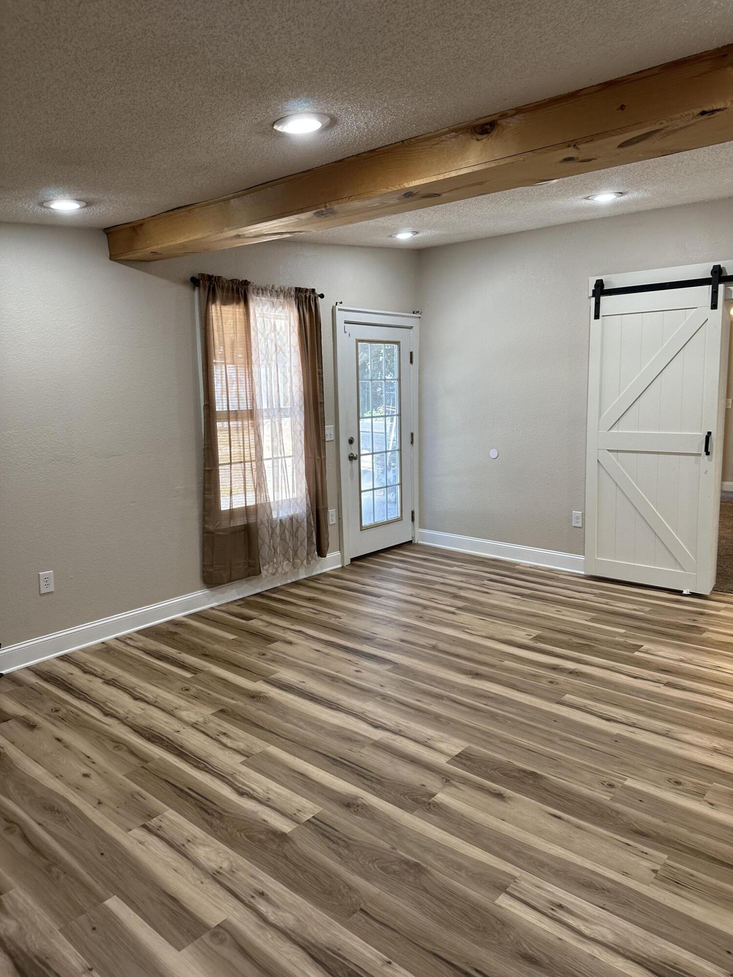 111 Sikes Drive Crestview, FL 32539 - Photo 8 of 20 a view of an empty room with wooden floor and a window