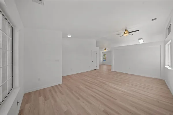 wooden floor in an empty room with a fan