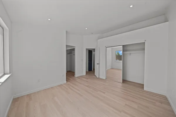 a view of empty room with wooden floor