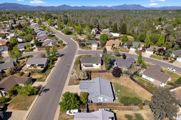 an aerial view of a city with lots of residential buildings and mountain view in back
