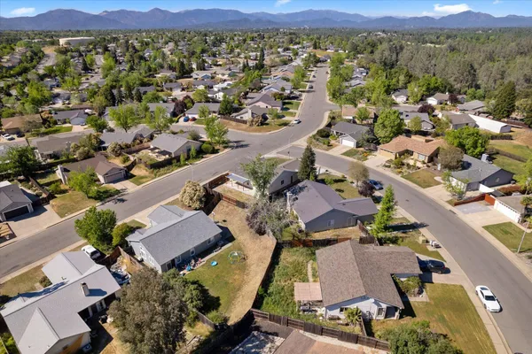 an aerial view of a city with lots of residential buildings and mountain view in back