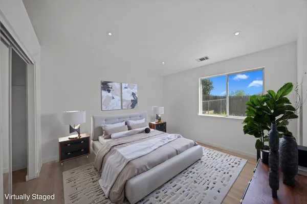 a bedroom with a large bed and a potted plant