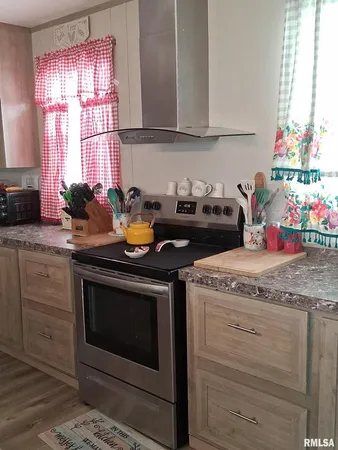 a kitchen with granite countertop wooden cabinets and a stove top oven