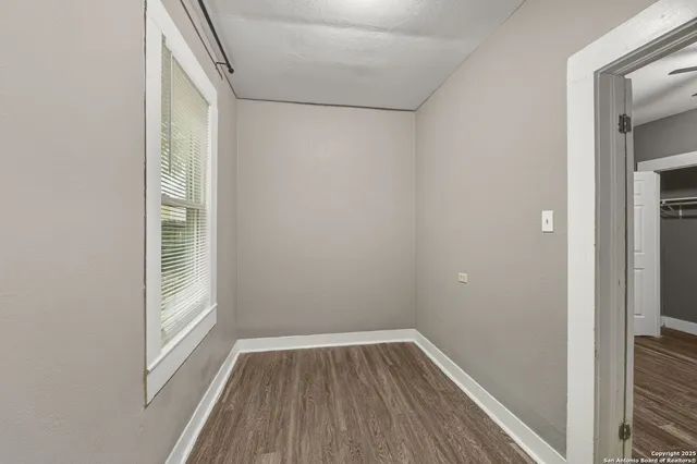 a view of a small space with wooden floor and a window