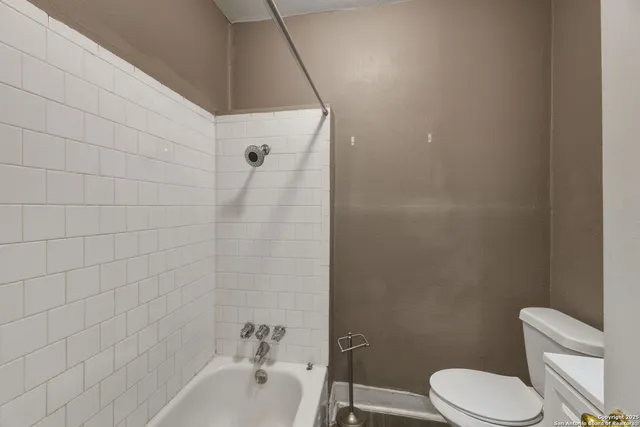 a white toilet sitting next to a bath tub