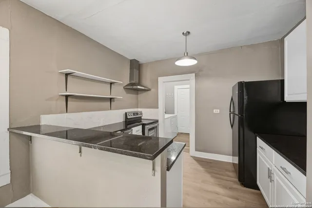 a kitchen with stainless steel appliances granite countertop a sink and a refrigerator