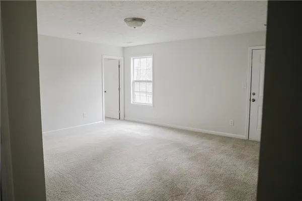 an empty room with windows and closet