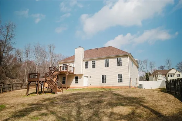 a view of a white house with a large trees