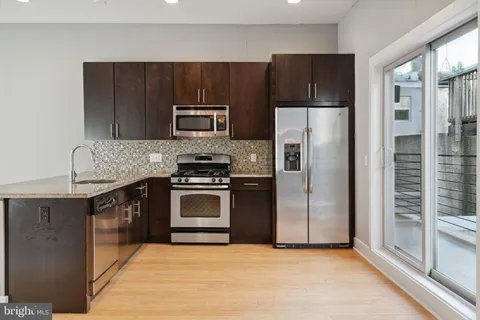 a kitchen with granite countertop a refrigerator and a stove