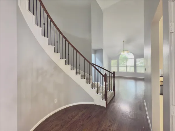 a view of staircase with wooden floor and white walls