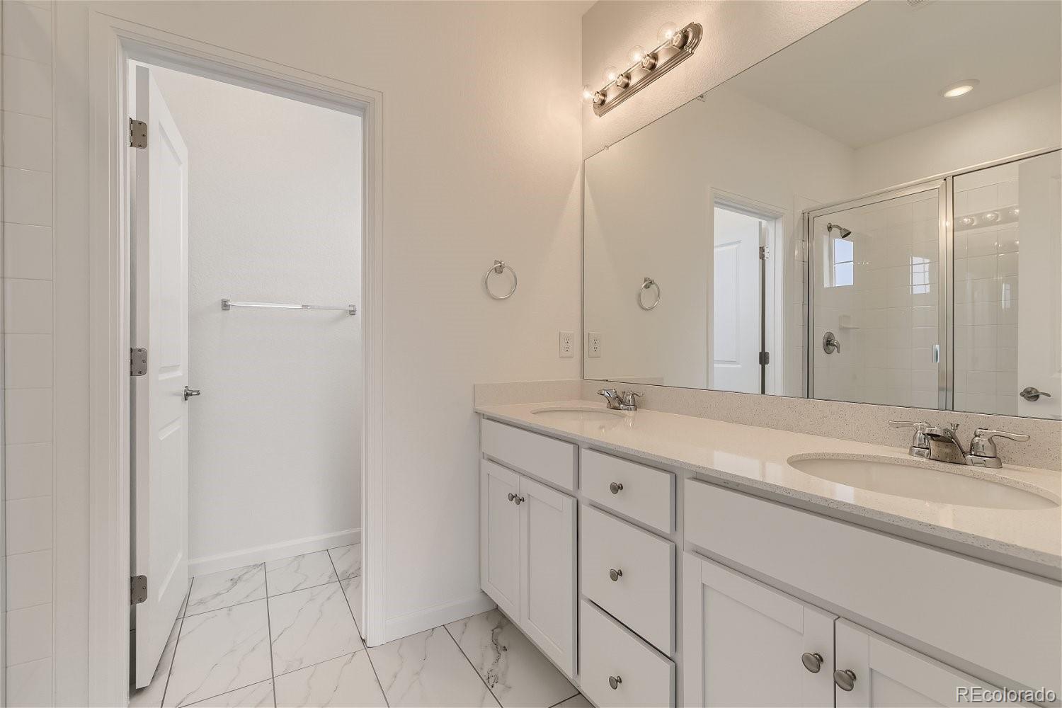 12659 Boggs Street Parker, CO 80134 - Photo 16 of 28 a bathroom with a double vanity sink and mirror
