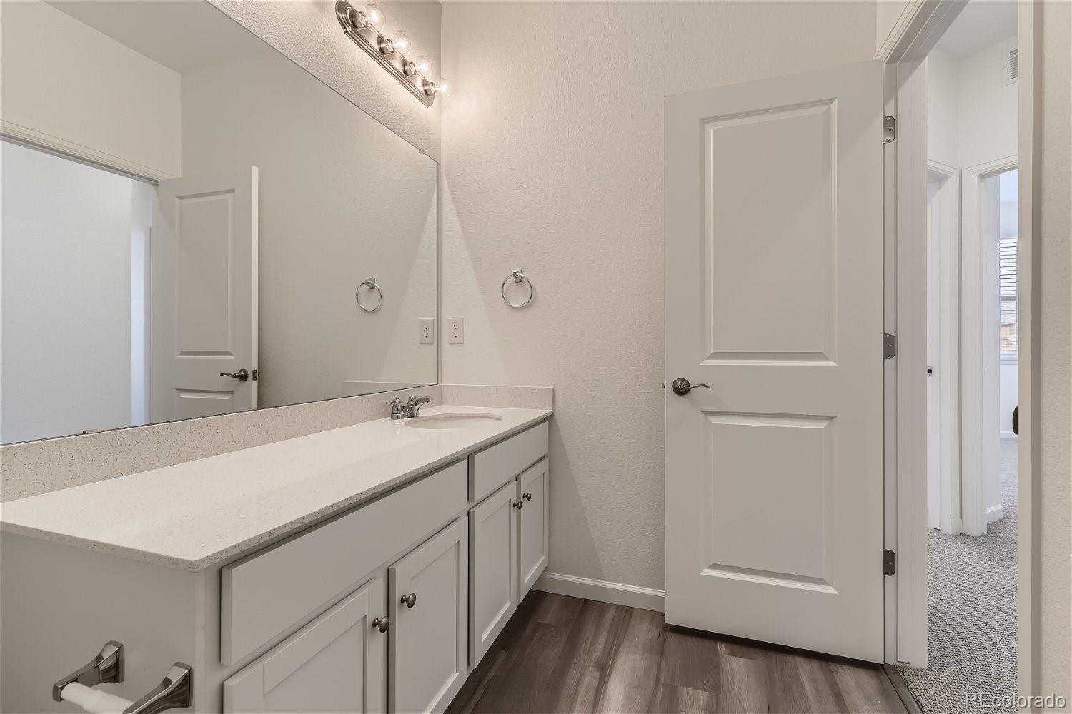 12659 Boggs Street Parker, CO 80134 - Photo 22 of 28 a bathroom with a sink a mirror and a shower