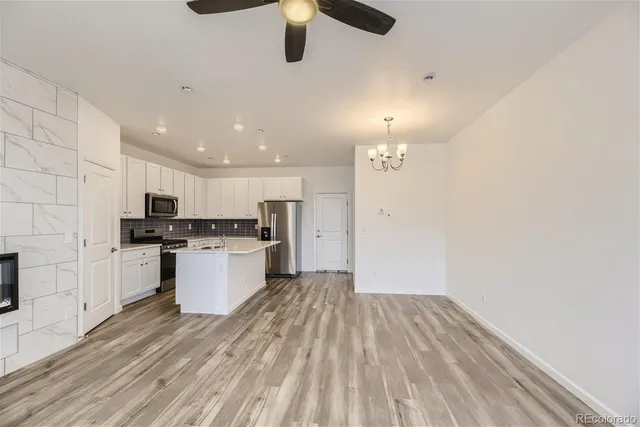 a kitchen with a refrigerator and white cabinets