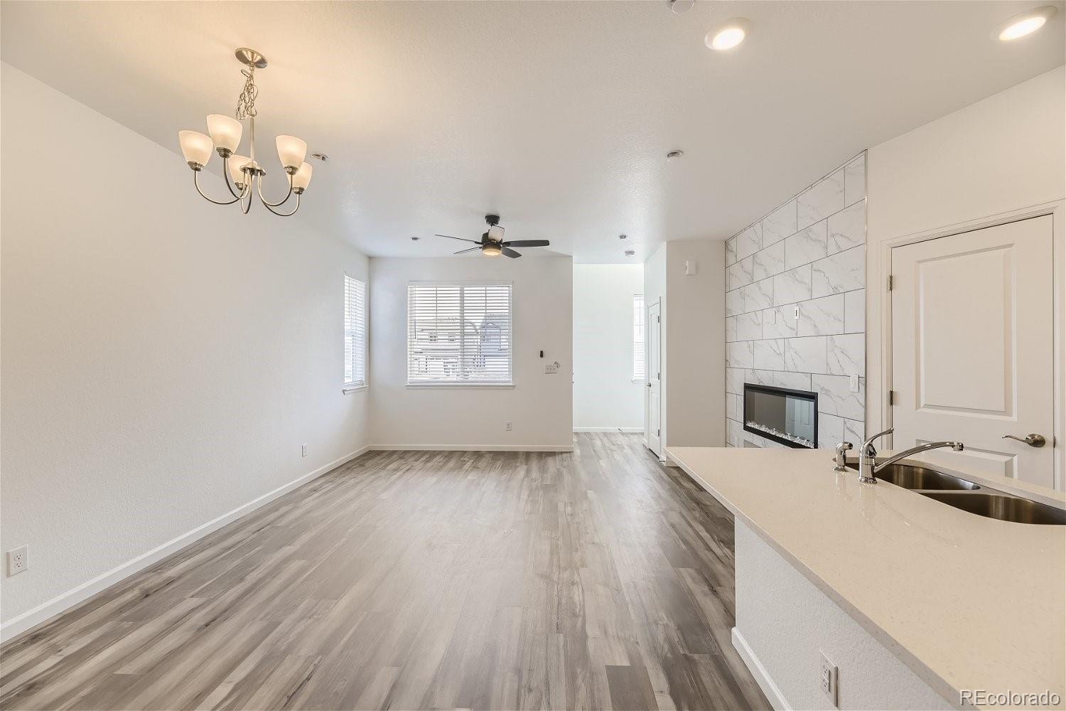 12659 Boggs Street Parker, CO 80134 - Photo 25 of 28 a view of a livingroom with wooden floor and a kitchen