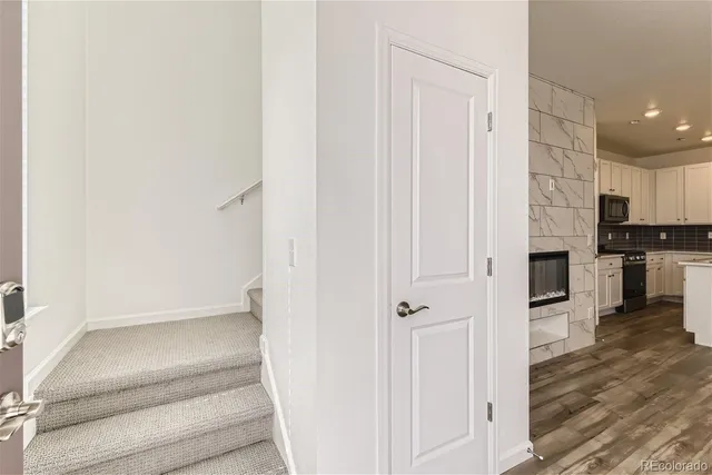 a view of a hallway with wooden floor and staircase