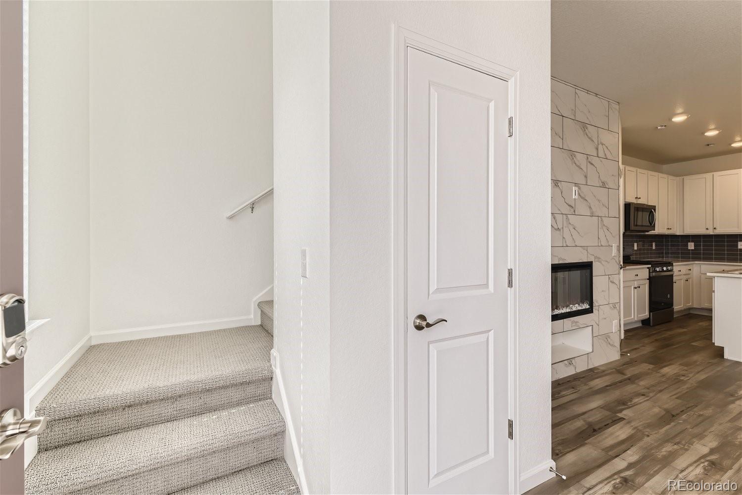 12659 Boggs Street Parker, CO 80134 - Photo 5 of 28 a view of a hallway with wooden floor and staircase