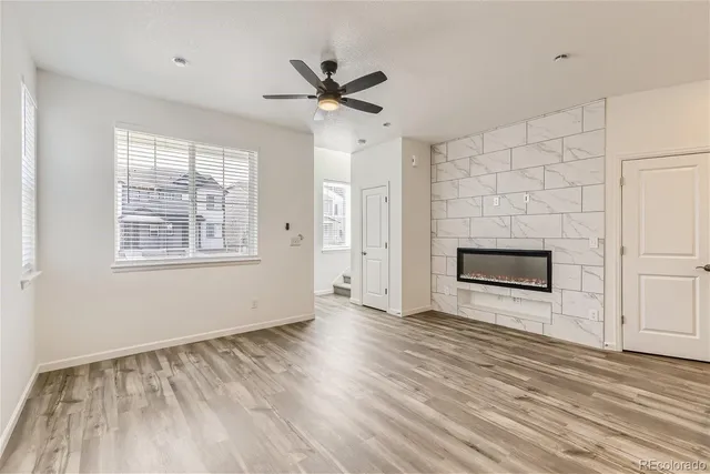 a view of empty room with wooden floor and fireplace
