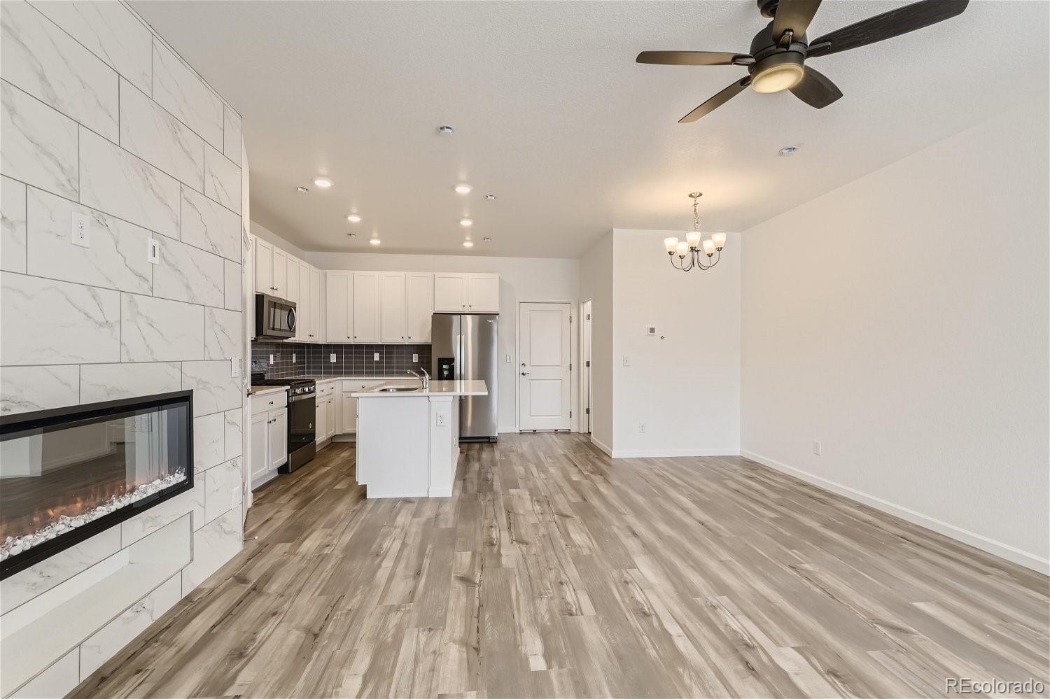 12659 Boggs Street Parker, CO 80134 - Photo 8 of 28 a kitchen with a refrigerator and a stove top oven