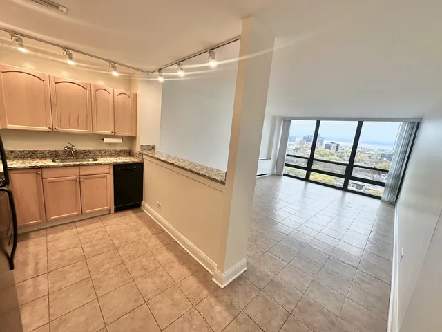 a kitchen with granite countertop a refrigerator and a sink