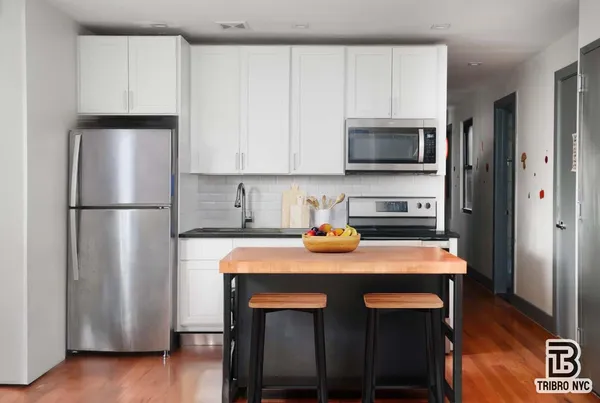 a kitchen with stainless steel appliances granite countertop a refrigerator a stove a sink and a microwave