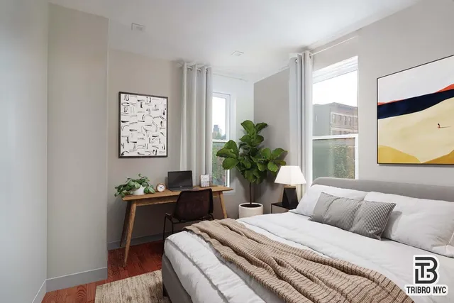 a bedroom with a bed table chair and window
