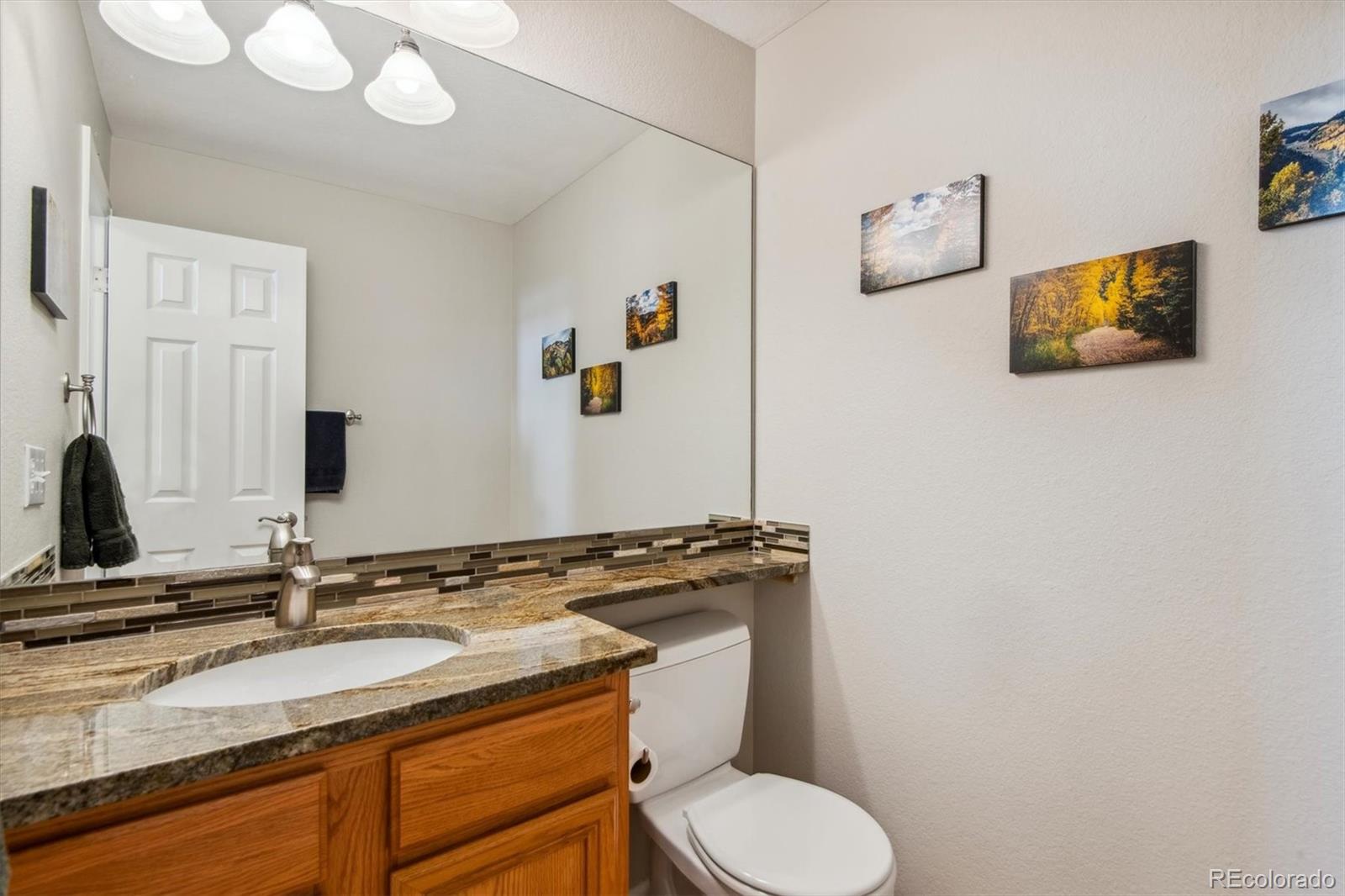 7749 Chaparral Road Lone Tree, CO 80124 - Photo 8 of 34 a bathroom with a granite countertop toilet sink and mirror