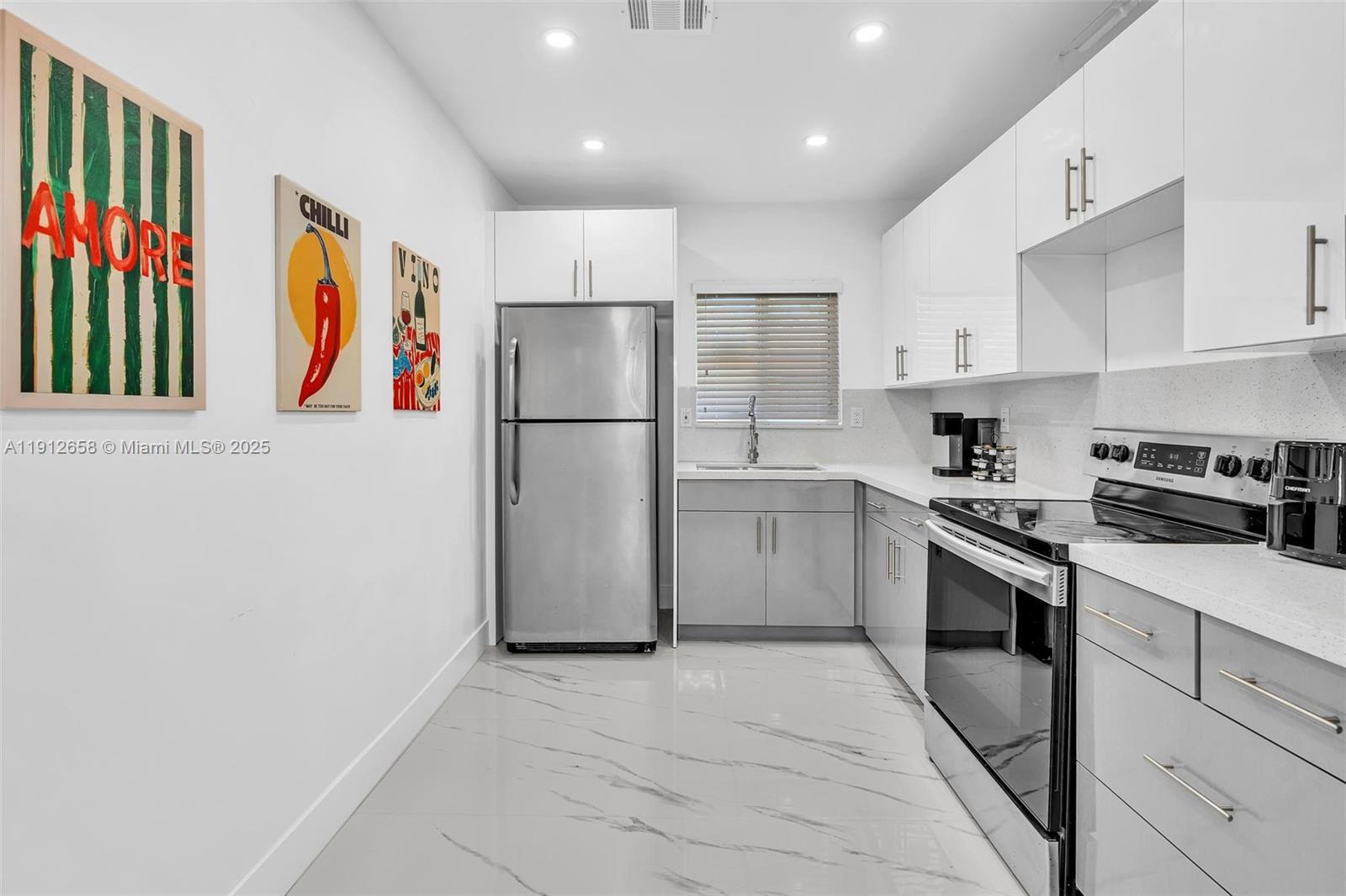 797 Northwest 35th Street Miami, FL 33127 - Photo 12 of 45 a kitchen with stainless steel appliances granite countertop a refrigerator sink stove and cabinets